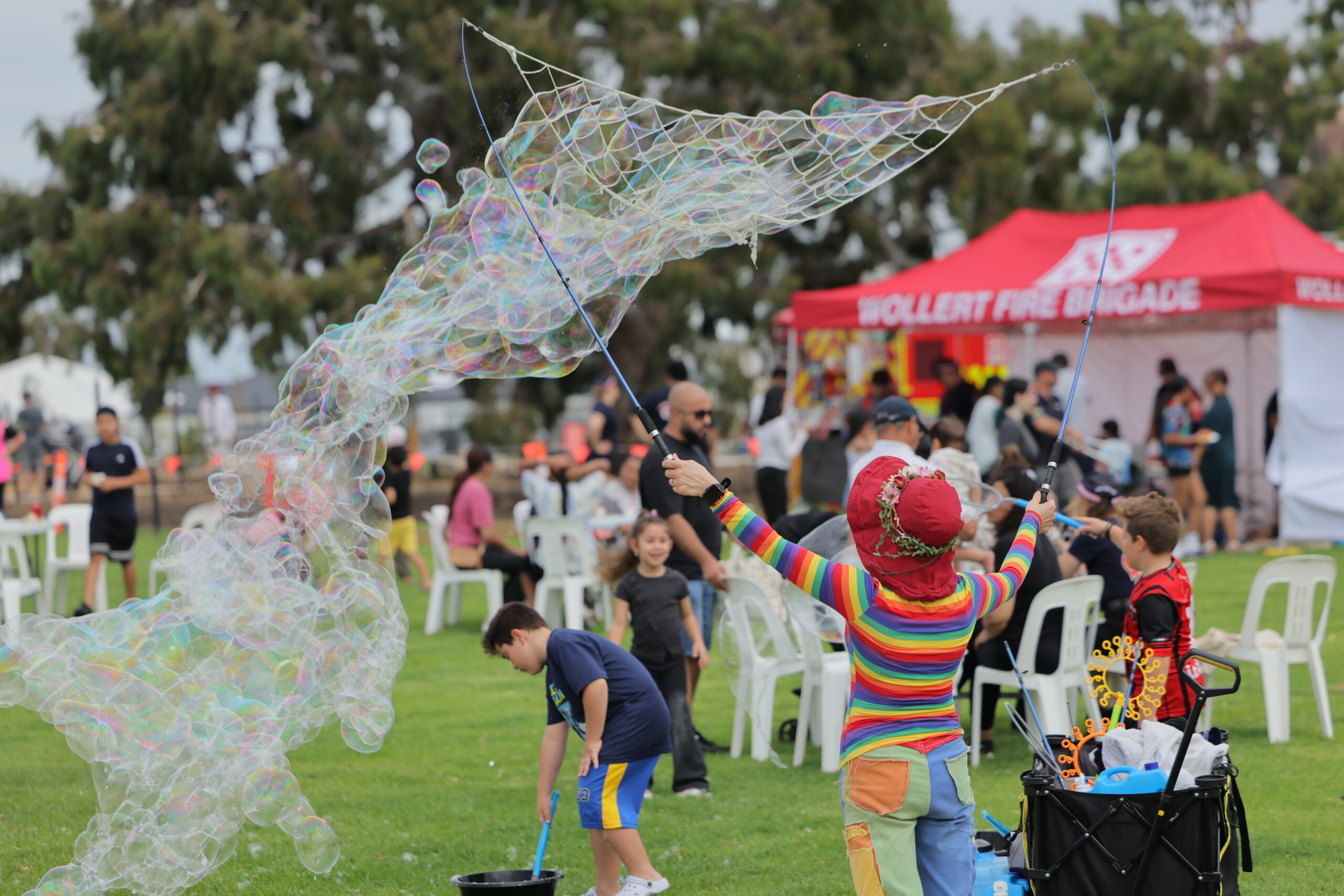 Performer creating giant bubbles at outdoor festival